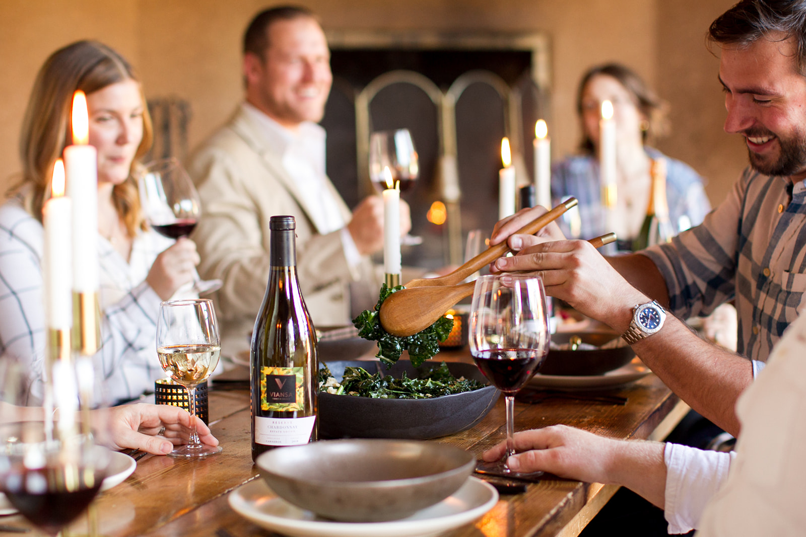 Friends sharing wine and a meal by candlelight